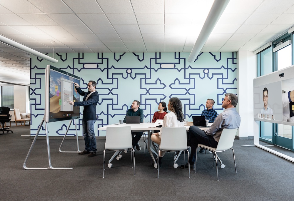 Ein Mann pr&auml;sentiert seinen Kollegen ein Projekt &uuml;ber das Webex Board Pro