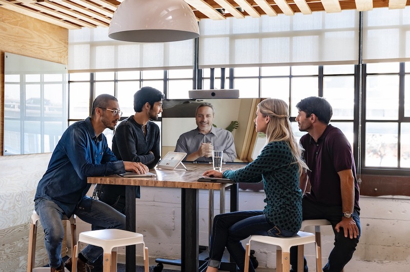 Ein Team arbeitet &uuml;ber das Room Kit mit einem Kollegen online zusammen
