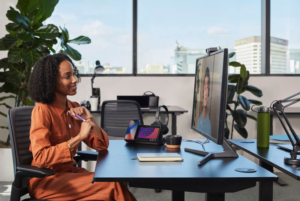 Eine Frau nutzt an ihrem Arbeitsplatz die Webex Desk Camera f&uuml;r eine gute Audio- und Videoqualit&auml;t im Onlinemeeting