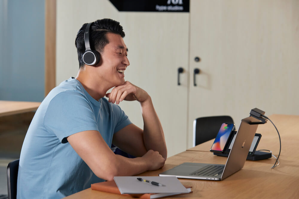 Ein Mann nutzt die Webex Desk Camera mit seinem Laptop, dem Desk Hub und Cisco 730 Headset für flexible und qualitativ hochwertige Meetings