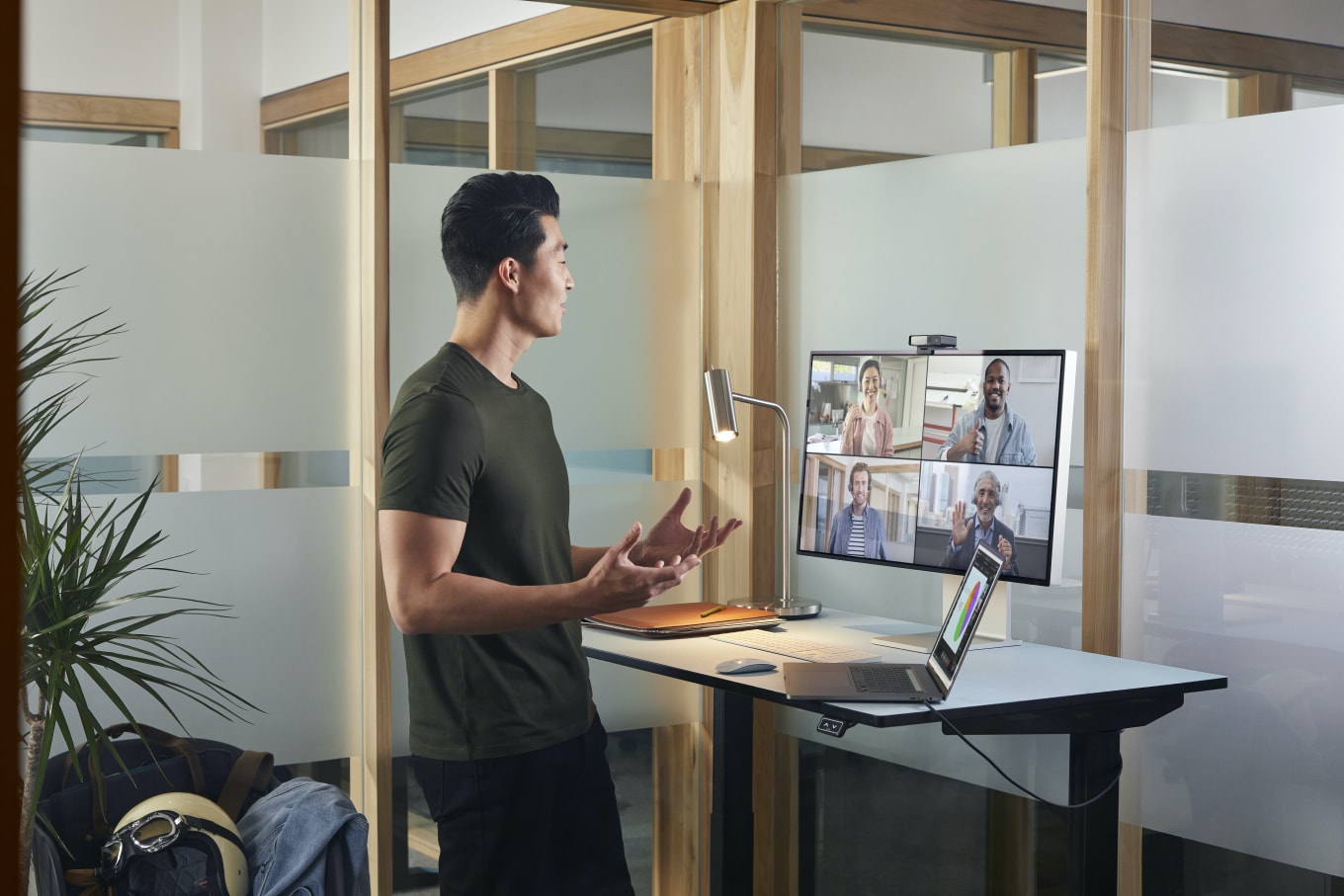 Ein Mann nimmt &uuml;ber die Webex Desk Camera an seinem Arbeitsplatz an einem Onlinemeeting teil