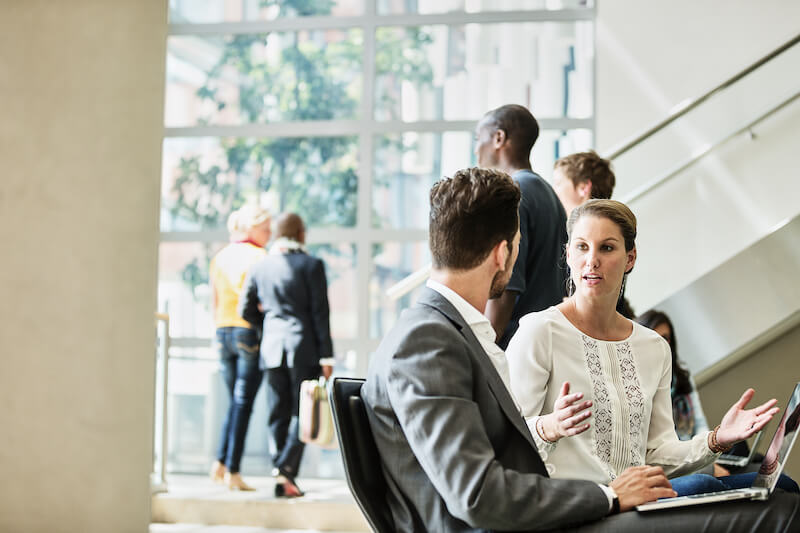 Eine Frau unterh&auml;lt sich mit einem Mann nach einem Meeting
