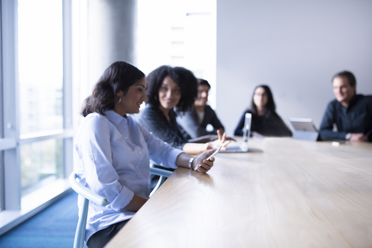 Ein Team sitzt am Meetingtisch und unterh&auml;lt sich