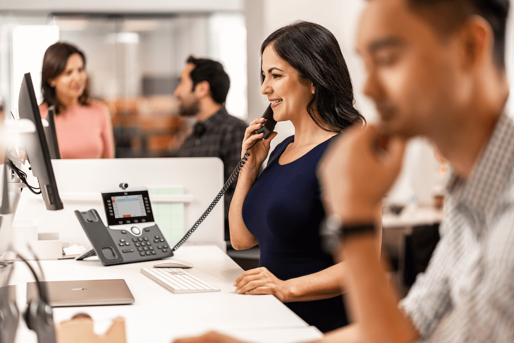 Eine Frau telefoniert im Büro mit ihrem Cisco IP-Telefon
