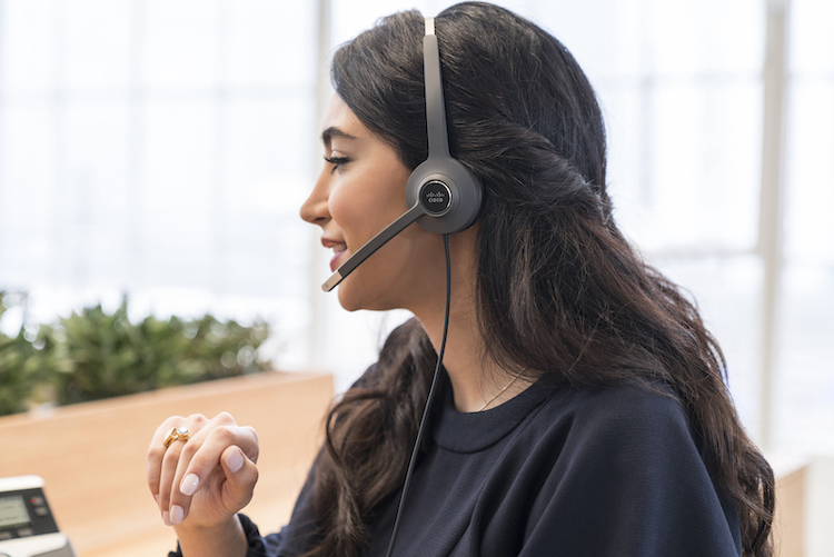 Eine Frau telefoniert &uuml;ber das kabelgebundene Headset