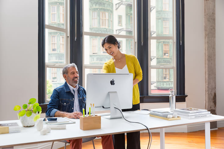 Eine Frau und ein Mann unterhalten sich im B&uuml;ro